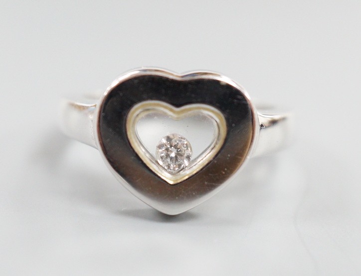 A modern 750 white metal and 'floating diamond' heart shape dress ring, size M, gross weight 6.4 grams.